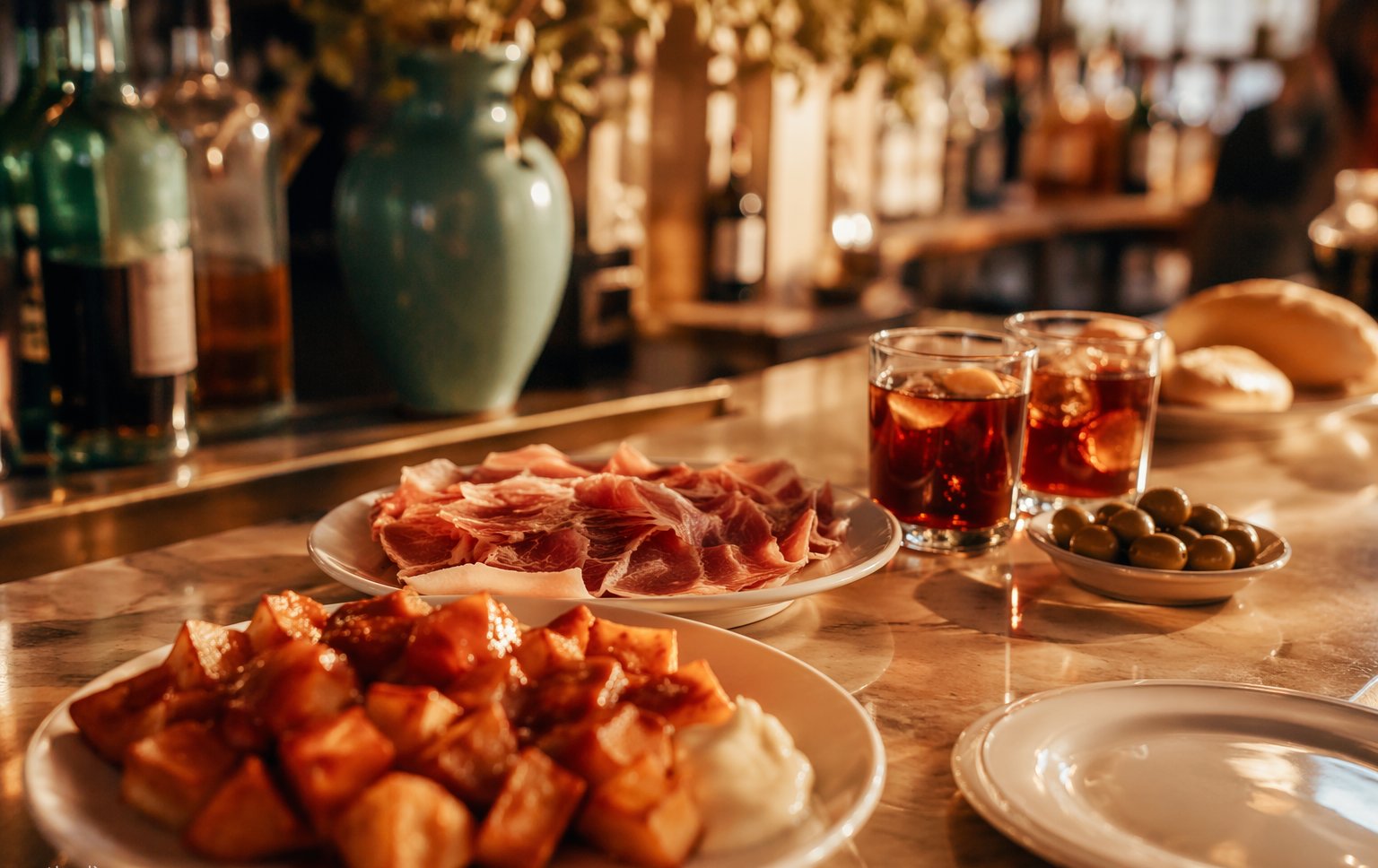 Jamón ibérico and small tapas plates on a zinc bar in a warm Madrid tavern at midnight